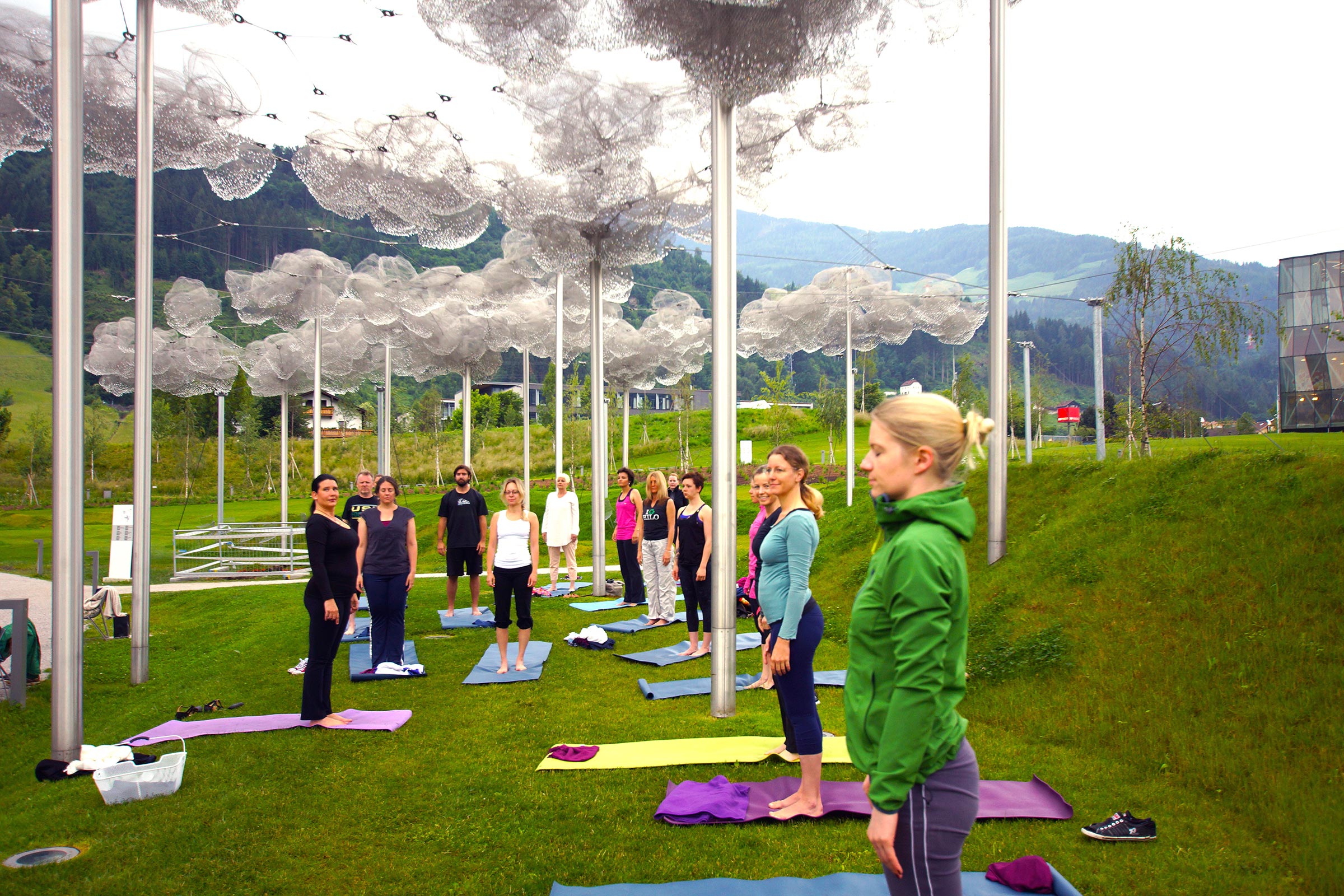 Yoga-Gruppe auf Matten unter den Kristallwolken