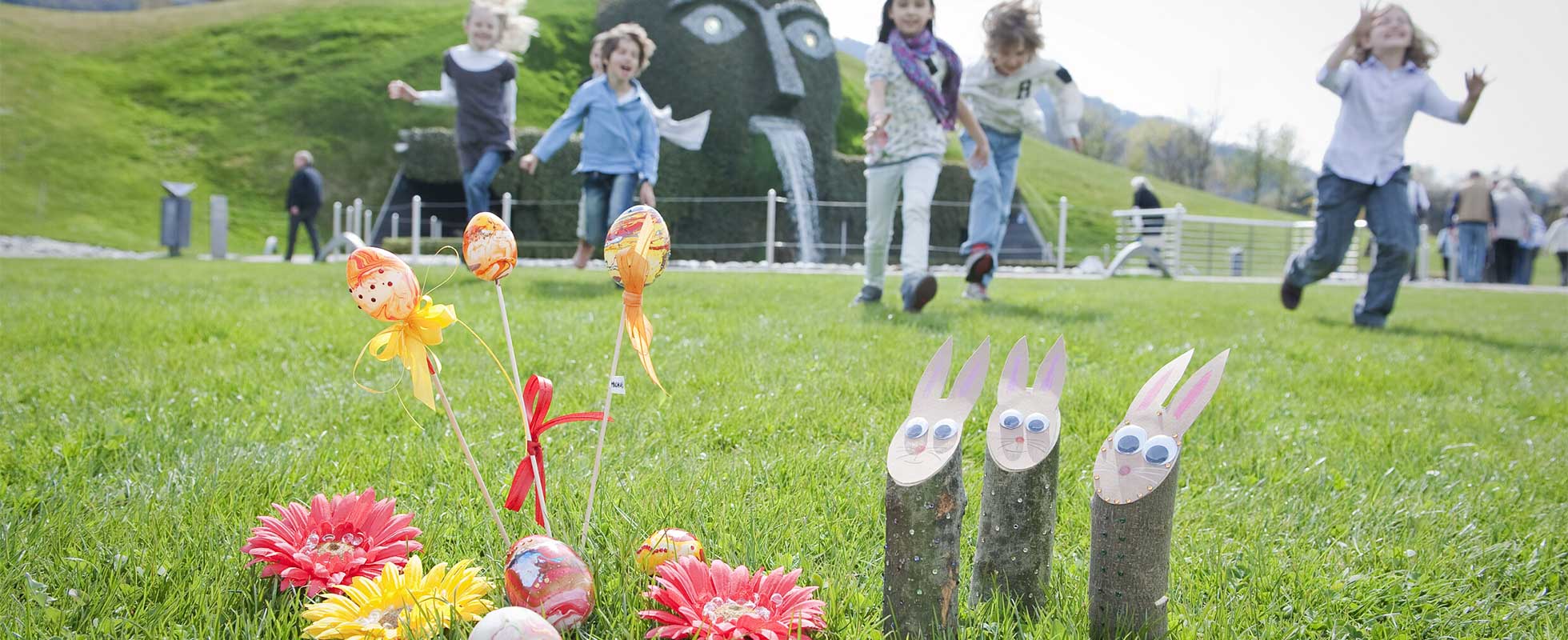 Kinder suchen Ostereier im Garten des Riesen