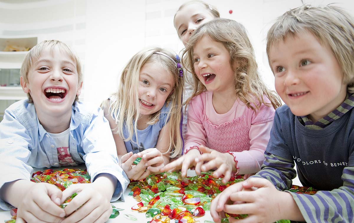 5 Kinder lachen und spielen mit Kristallen